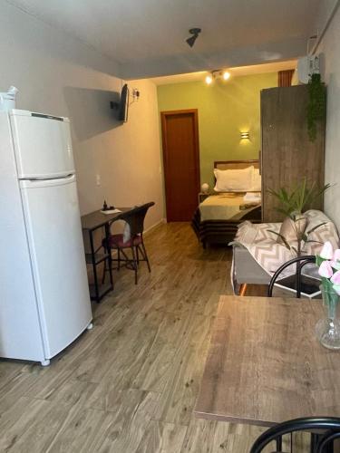 a living room with a white refrigerator and a table at Espaço da Zilda in São José