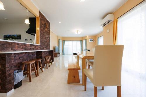 a dining room with a table and some chairs at オーシャンビューテラス伊豆 in Futo