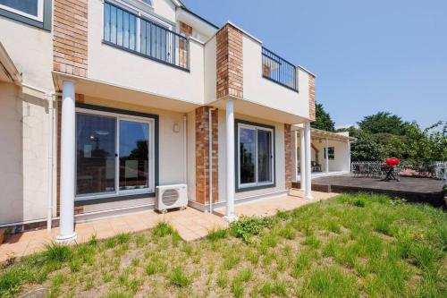 a house with a lawn in front of it at オーシャンビューテラス伊豆 in Futo