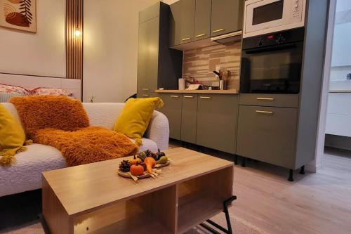 - un salon avec un canapé et une table avec des fruits dans l'établissement Mohd'or 3 Calais, à Calais Saint-Pierre