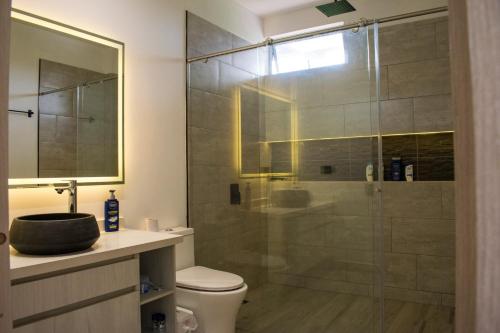 a bathroom with a toilet and a glass shower at Suite de Lujo con Entrada Privada Cerca al Aeropuerto El Edén in La Tebaida