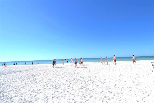 a group of people walking on the beach at Newly remodeled 8-steps to sand path of Beach! Unit A in Siesta Key