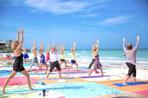 a group of people doing yoga on the beach at Newly remodeled 8-steps to sand path of Beach! Unit A in Siesta Key