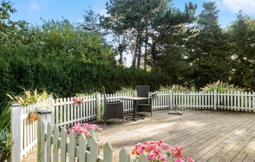 a white fence with a table and chairs on a wooden deck at 3 Bedroom Cozy Home In Nykøbing Sj in Lumsås