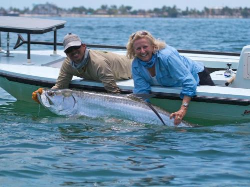 two people on a boat with a large fish in the water at Newly remodeled 8-steps to sand path of Beach! Unit D in Siesta Key