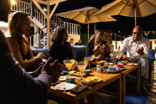 a group of people sitting around a table in a restaurant at Harbour View Boutique Hotel & Wellness Retreat in Belize City