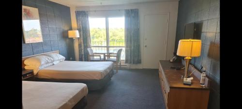a hotel room with two beds and a balcony at The Inn At Lock Seven in Thorold