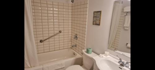 a bathroom with a tub and a toilet and a sink at The Inn At Lock Seven in Thorold