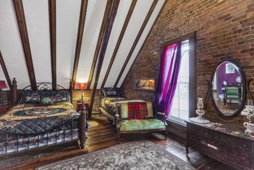 a bedroom with two beds and a brick wall at DuPriest Room at Main Street Bed & Breakfast in Glasgow