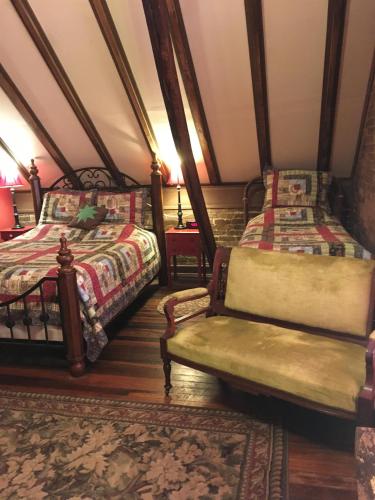 a room with two beds and a couch and a chair at DuPriest Room at Main Street Bed & Breakfast in Glasgow