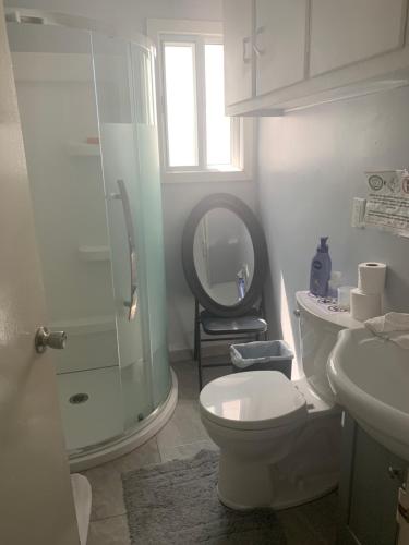 a bathroom with a toilet and a sink and a mirror at Montréal Steps Downtown Private Rooms in Montreal
