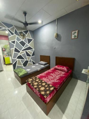 a bedroom with two beds and a ceiling at D'Murni Beach Homestay in Yan