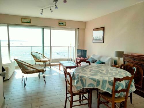 - un salon avec une table et des chaises et une vue sur l'océan dans l'établissement Appartement T2 face plage, confortable, balcon, 4 pers., prox. centre, parking, ascenseur - FR-1-331-9, à Les Sables-dʼOlonne