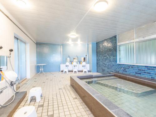 a bathroom with a tub and toilets in it at 旅館御宿Tabist Ritsurinsanso in Takamatsu