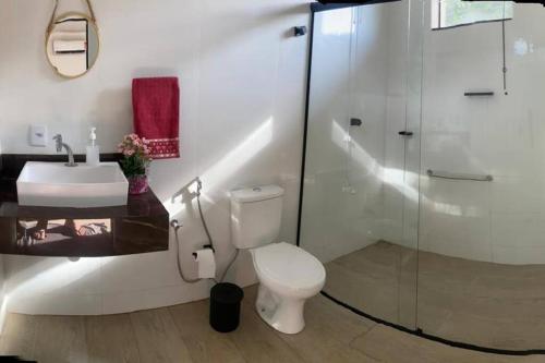 een badkamer met een toilet, een wastafel en een douche bij El Badan Hospedagem - Casa 3 in Olímpia