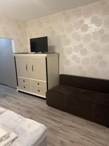 a living room with a couch and a tv at Pension Veľký Meder in Ižop