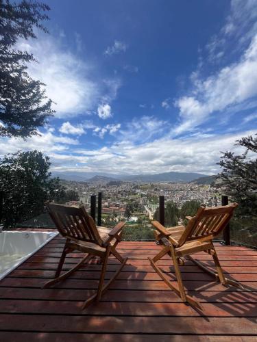two chairs sitting on top of a wooden deck at Colina de San Pedro Glamping con Jacuzzi in Duitama