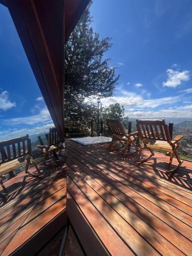 a deck with chairs and a view of the mountains at Colina de San Pedro Glamping con Jacuzzi in Duitama