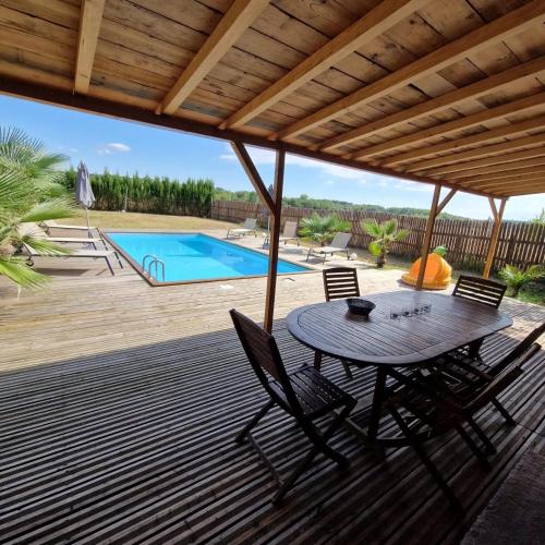 un patio avec une table et des chaises et une piscine dans l'établissement Villa familiale à Bazac avec piscine privée, à Bazac