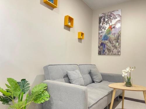 a living room with a couch and a painting on the wall at Bungaluxe Jealya - Terrasse et Parking in Saint-Laurent du Maroni