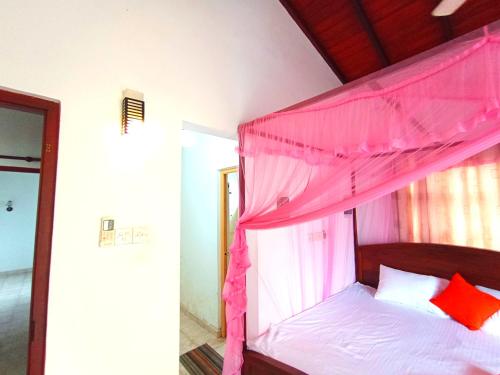 a bed with a pink canopy in a room at Calm Nature Villa in Matara