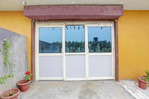 a large white garage door with two windows at Hotel O Dwarka in Alīgarh