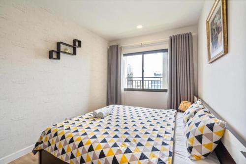 a bedroom with a bed with a checkered blanket at 1br-Stunning View-Hana Apart in Ho Chi Minh City