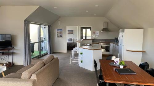 a living room and kitchen with a couch and a table at Lake Tekapo Village Motel in Lake Tekapo