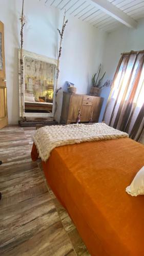 a bedroom with an orange bed in a room at Magia in Roldán