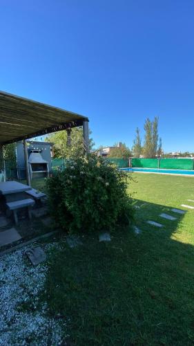 a picnic table and a bush in a yard at Magia in Roldán