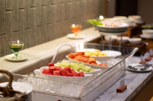 a buffet with two plates of fruit on a counter at Oakwood Merdeka Bandung in Bandung