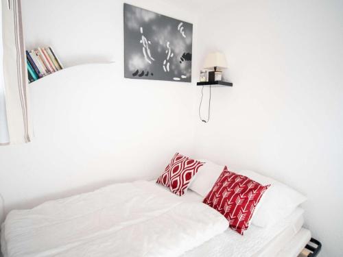 - un lit avec des oreillers rouges et blancs dans l'établissement Appartement cosy 4 pers, Val Thorens, proche commerces et pistes - FR-1-637-67, à Val Thorens