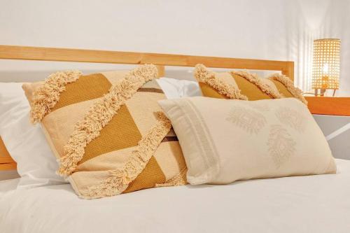 a pile of pillows sitting on top of a bed at OASIS Punta Cana Apartment in Punta Cana
