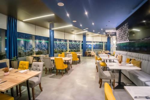 a dining room with tables and yellow chairs at Wyndham Garden Guayaquil in Guayaquil