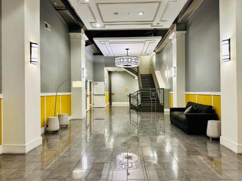 a lobby with a couch and stairs in a building at Two Bedroom Game Day Suite with 100 Projector TV in Indianapolis