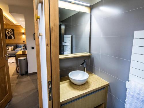 La salle de bains est pourvue d'un lavabo et d'un bol sur un comptoir. dans l'établissement Appartement de standing calme avec terrasse, espace bien-être et parking privé - FR-1-346-577, à Arc 1800