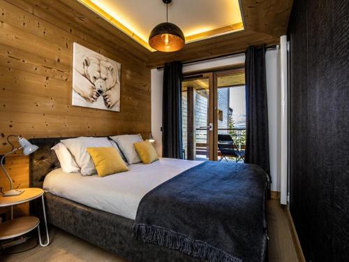 une chambre avec un grand lit dans une pièce aux murs en bois dans l'établissement Appartement de standing calme avec terrasse, espace bien-être et parking privé - FR-1-346-577, à Arc 1800