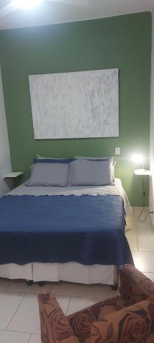 a bedroom with a blue bed with a green wall at Small quiet condo posto 6 in Rio de Janeiro