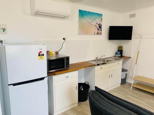 a kitchen with a white refrigerator and a microwave at Port Lincoln Caravan Park in North Shields