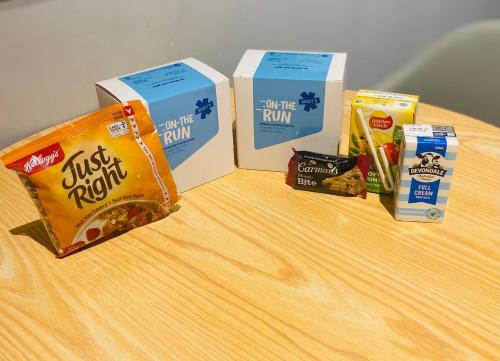 Tres cajas de muffins y otros bocadillos sobre una mesa. en Clarion Apartments South Melbourne, en Melbourne