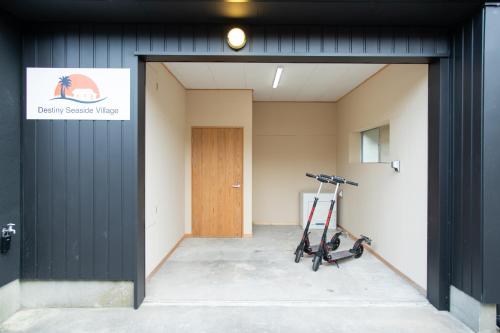 an empty room with a door and a scooter in it at Destiny Seaside Village in Sakaiminato
