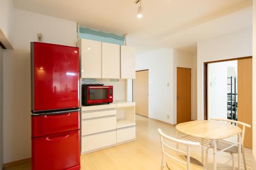 a red refrigerator in a kitchen with a table at Destiny Seaside Village in Sakaiminato