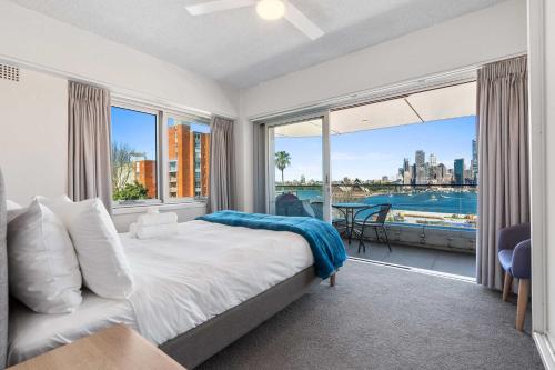a bedroom with a bed and a large window at Dream Views of Sydney CBD in Sydney