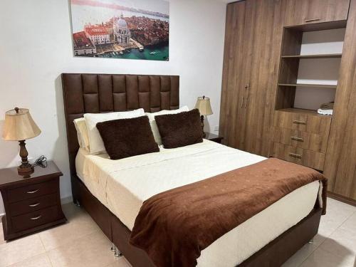 a bedroom with a large bed with a wooden headboard at Cómodo apto con parqueadero in Pitalito