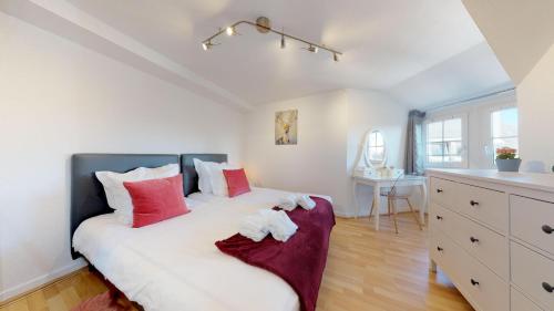 une chambre avec un lit avec des oreillers rouges et blancs dans l'établissement Bail Mobilité Rue du 22 Novembre, à Strasbourg