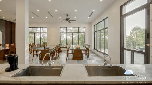 a kitchen with two sinks and a dining room at Mây Trắng Villa and FarmStay in Ba Vì