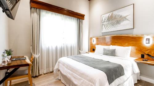 a bedroom with a large bed and a window at Hotel Boutique Los Abetos in Boquete