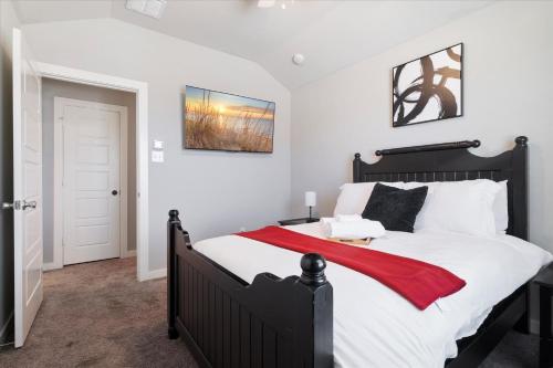 a bedroom with a large bed with a red blanket at The Aubrey Escape with Fenced Backyard in Aubrey