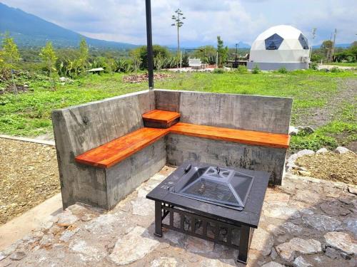 a wooden bench with a table and a grill at Cabaña Gepetto in Cardonal