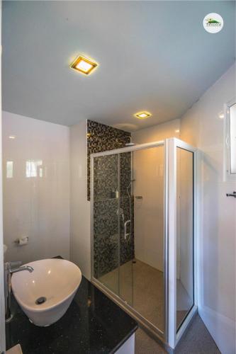 a bathroom with a shower and a sink and a toilet at Phukaew Resort & Adventure Park in Khao Kho